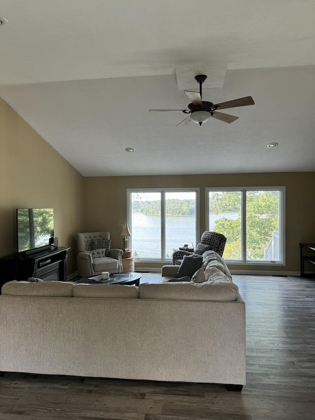 living room with plenty of natural light, a water view, and dark hardwood / wood-style floors