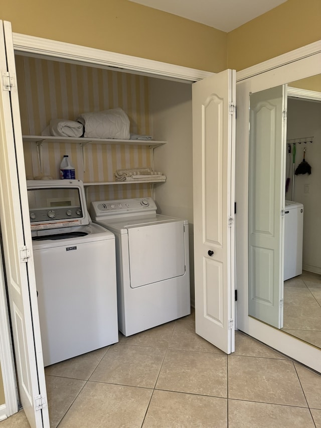 laundry area featuring separate washer and dryer and light tile patterned floors