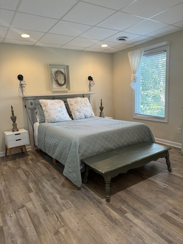 bedroom featuring hardwood / wood-style floors and a paneled ceiling