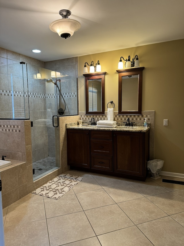 bathroom with backsplash, tile patterned flooring, vanity, and a shower with door