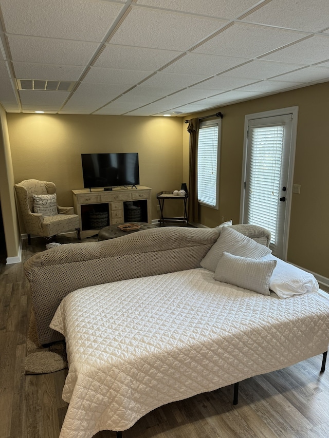 bedroom with wood-type flooring and a drop ceiling