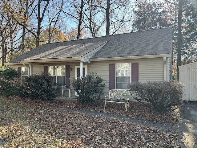 view of front of property with a porch and a storage shed