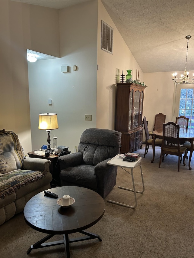 carpeted living room with a textured ceiling, high vaulted ceiling, and a chandelier