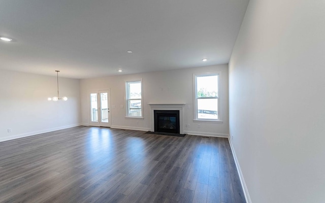 7938 Pine St, Fairview, TN 37062 - unfurnished living room with baseboards, dark wood-type flooring, a glass covered fireplace, recessed lighting, and a chandelier