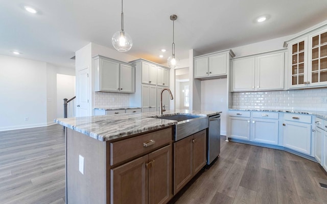 7938 Pine St, Fairview, TN 37062 - kitchen with a sink, stainless steel dishwasher, wood finished floors, backsplash, and light stone countertops