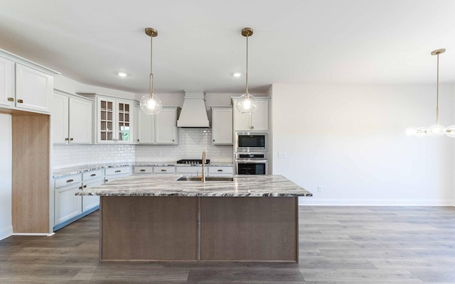 7938 Pine St, Fairview, TN 37062 - kitchen with custom range hood, a sink, baseboards, light stone counters, and recessed lighting