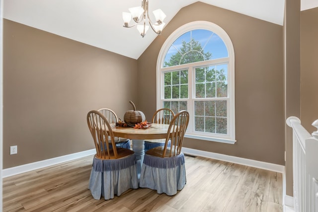 dining space featuring a chandelier, lofted ceiling, and light hardwood / wood-style floors