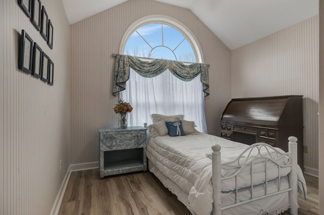 bedroom with hardwood / wood-style flooring and lofted ceiling