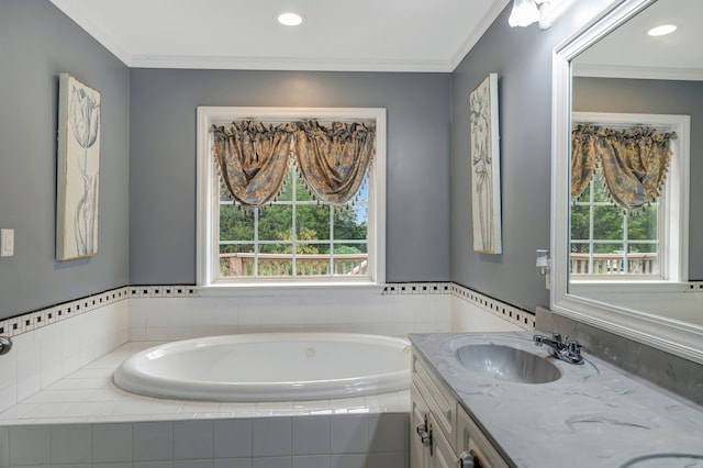 bathroom featuring vanity, ornamental molding, and tiled bath