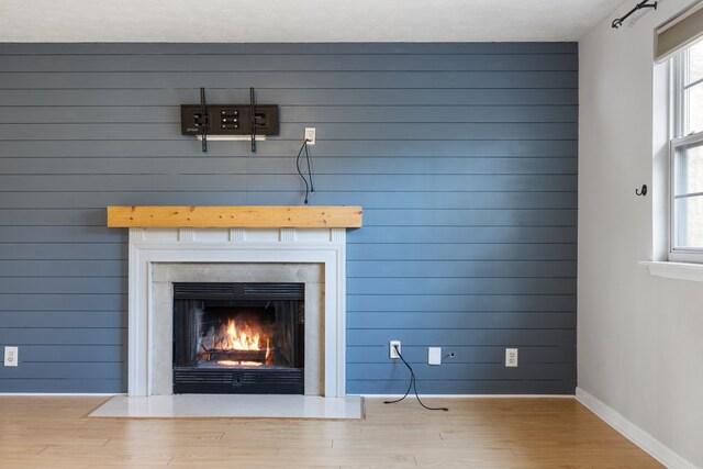 interior details featuring wood-type flooring, a textured ceiling, and wooden walls