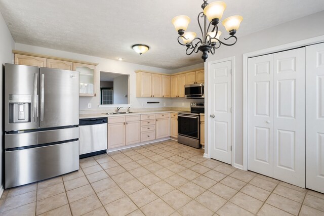 kitchen featuring sink, light brown cabinets, a chandelier, and appliances with stainless steel finishes