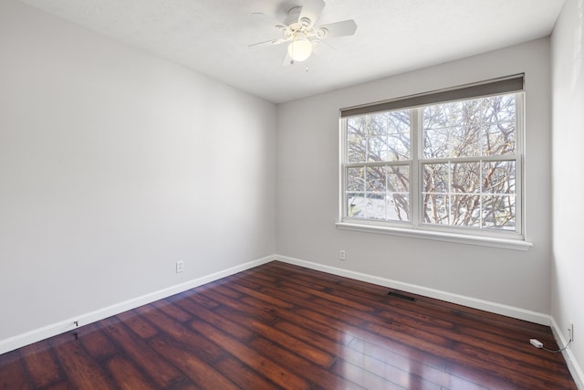 spare room featuring ceiling fan and dark wood-type flooring