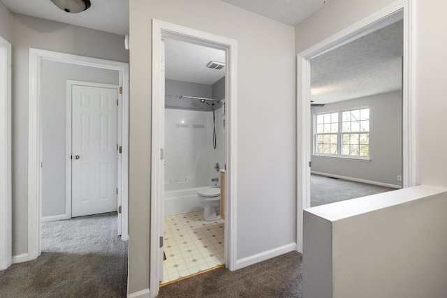 bathroom featuring shower / washtub combination, tile patterned flooring, a textured ceiling, and toilet