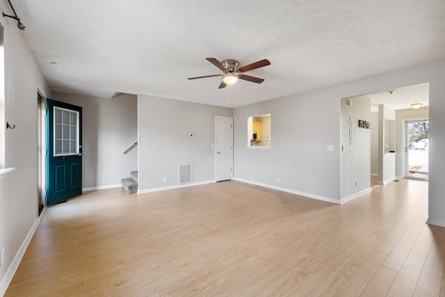 unfurnished room with a textured ceiling, light hardwood / wood-style floors, and ceiling fan