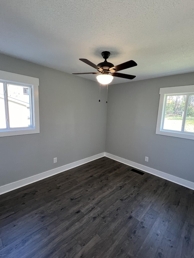 unfurnished room with ceiling fan, dark hardwood / wood-style flooring, and a textured ceiling