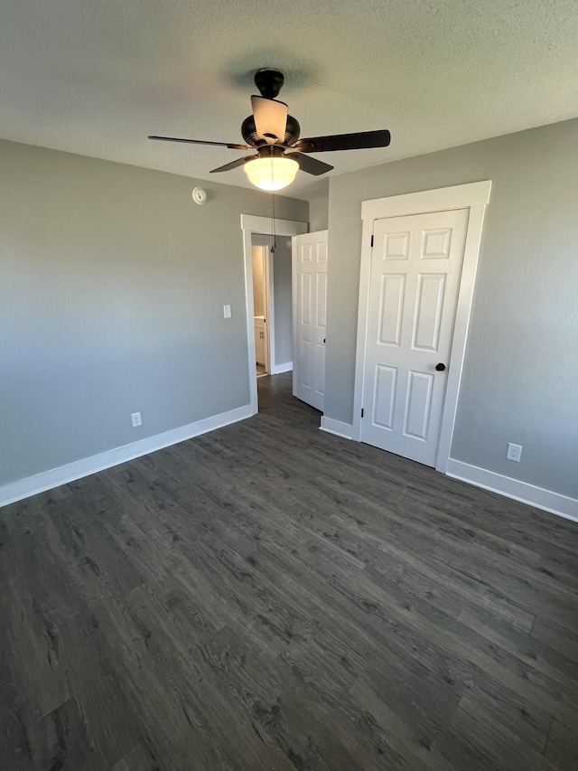 unfurnished bedroom featuring a textured ceiling, ceiling fan, a closet, and dark hardwood / wood-style floors