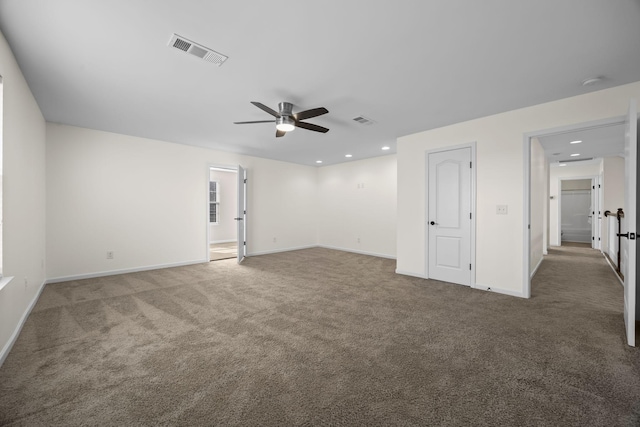 empty room with dark colored carpet and ceiling fan