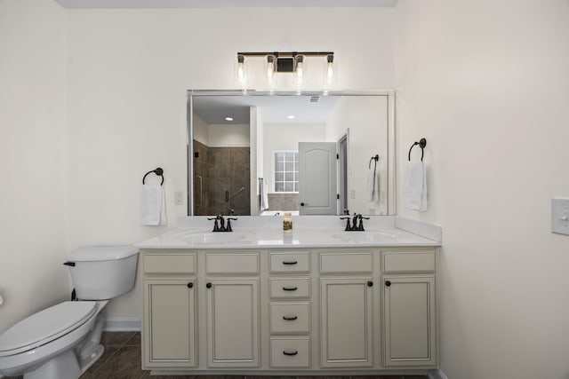 bathroom with tiled shower, tile patterned floors, vanity, and toilet