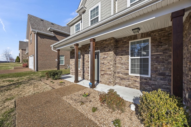 doorway to property featuring covered porch and a garage