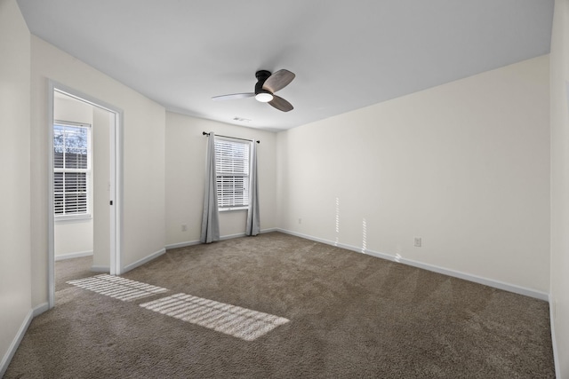 spare room with ceiling fan and carpet