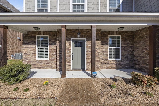 doorway to property featuring a porch and central air condition unit