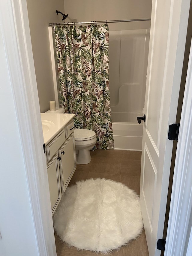 bathroom featuring toilet, shower / bath combination with curtain, and vanity