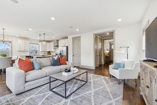 living room with sink, dark hardwood / wood-style flooring, and an inviting chandelier