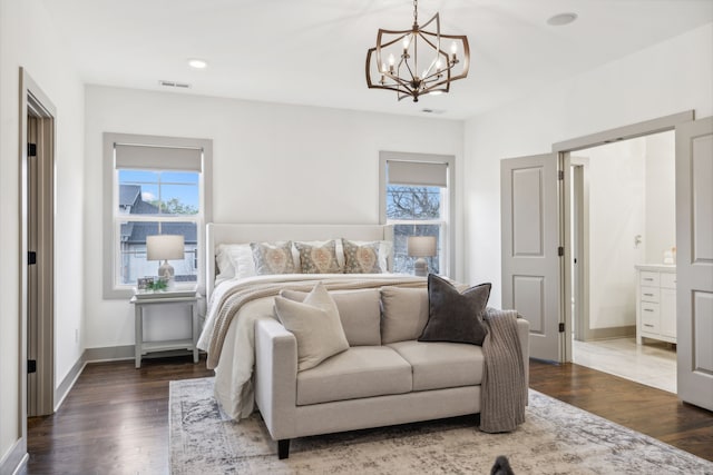 bedroom with connected bathroom, an inviting chandelier, multiple windows, and dark wood-type flooring