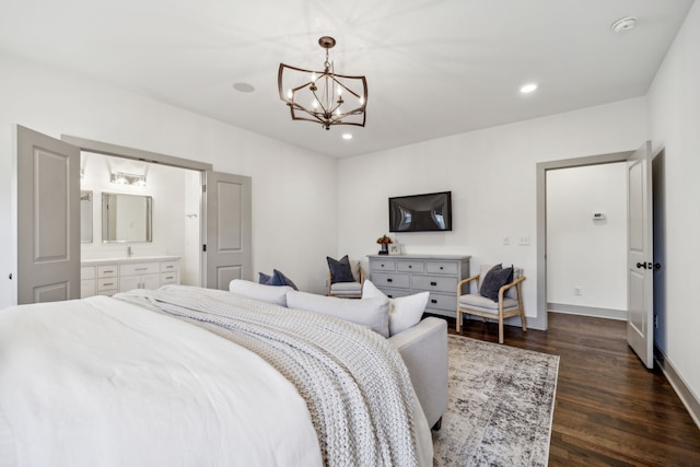 bedroom featuring dark hardwood / wood-style flooring, ensuite bathroom, and a notable chandelier