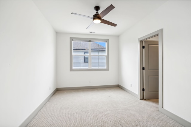 empty room featuring ceiling fan and light colored carpet