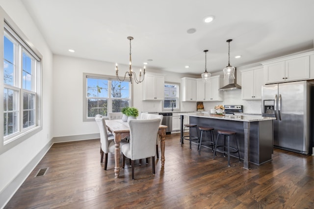 dining room with dark wood-type flooring and an inviting chandelier