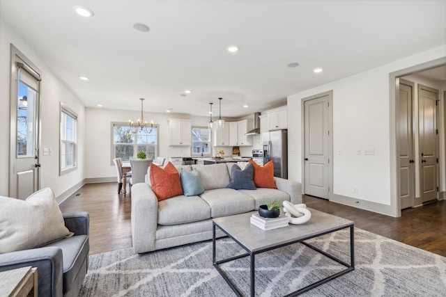 living room featuring a chandelier and dark wood-type flooring