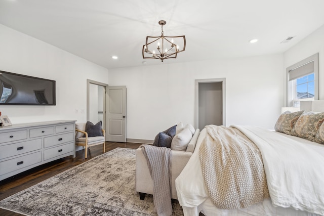 bedroom with dark hardwood / wood-style floors and an inviting chandelier