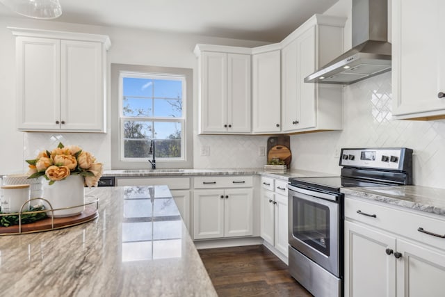 kitchen featuring white cabinets, light stone countertops, wall chimney range hood, and stainless steel range with electric cooktop