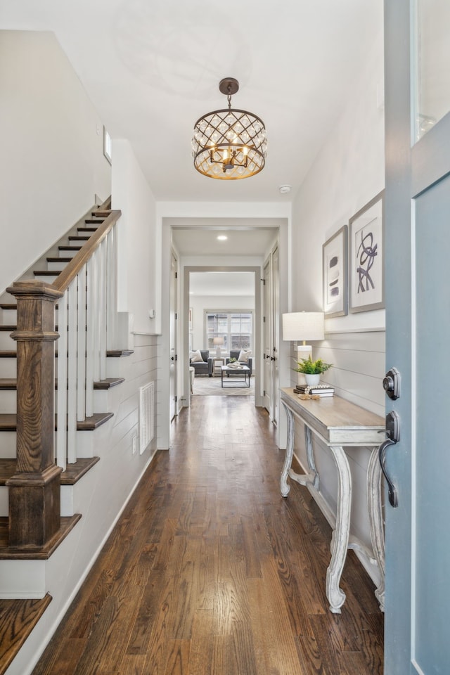 entrance foyer with dark hardwood / wood-style flooring and an inviting chandelier