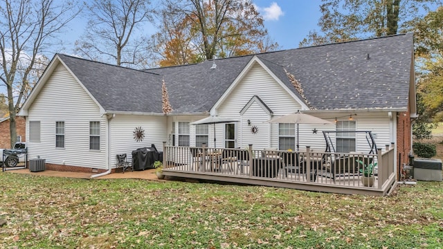 rear view of property featuring a deck, cooling unit, and a lawn