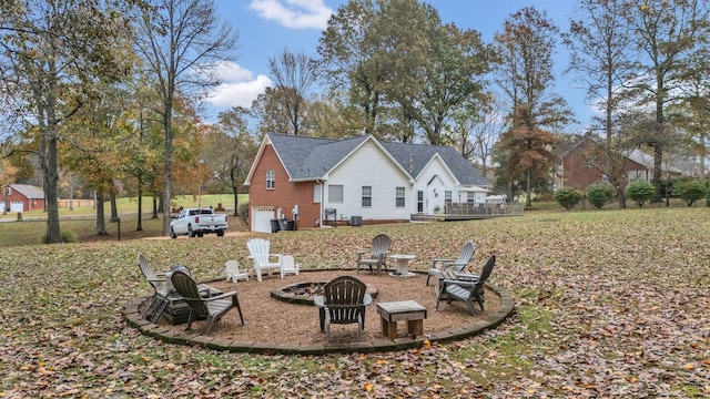 view of yard with a wooden deck, a fire pit, and a garage