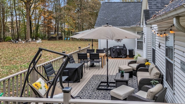 wooden deck with an outdoor living space and a grill