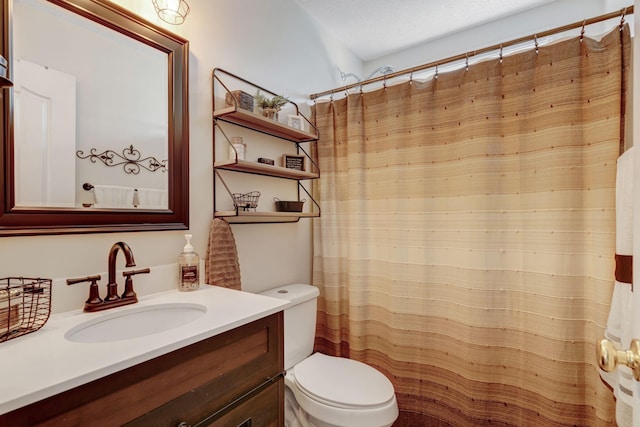 bathroom featuring vanity, a textured ceiling, and toilet