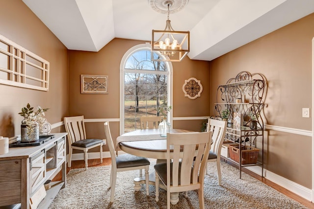 dining space featuring vaulted ceiling, light hardwood / wood-style flooring, and an inviting chandelier