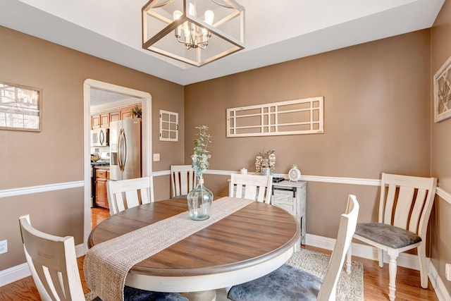 dining area with a notable chandelier and light hardwood / wood-style floors