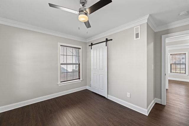 unfurnished bedroom featuring a barn door, ceiling fan, dark wood-type flooring, and ornamental molding