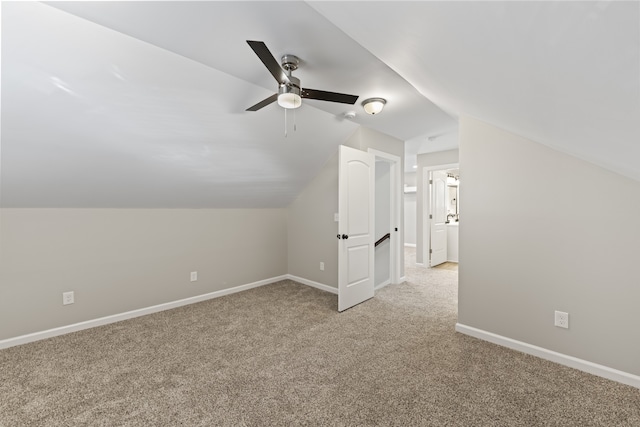 additional living space featuring ceiling fan, light colored carpet, and vaulted ceiling