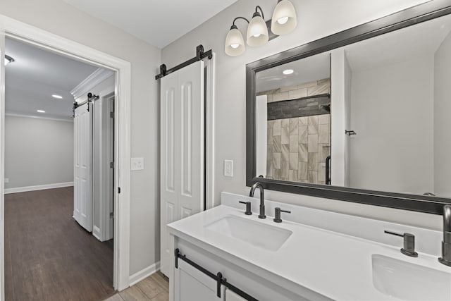 bathroom with hardwood / wood-style flooring, vanity, and tiled shower