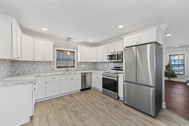 kitchen with light hardwood / wood-style floors, sink, stainless steel appliances, and a wealth of natural light