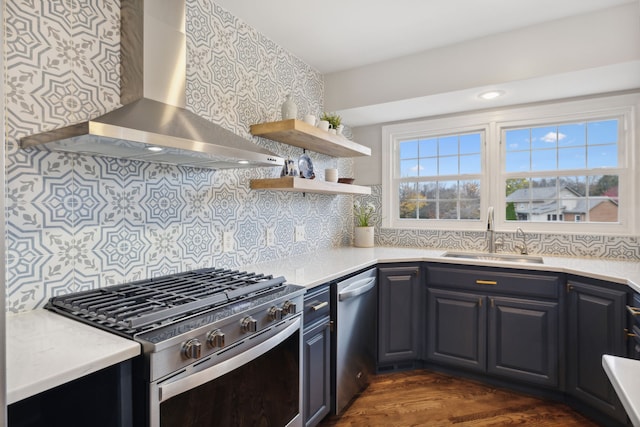 kitchen featuring sink, stainless steel appliances, wall chimney range hood, dark hardwood / wood-style flooring, and backsplash