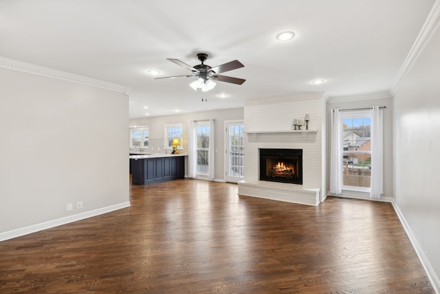 unfurnished living room with dark hardwood / wood-style floors, ceiling fan, ornamental molding, and a fireplace