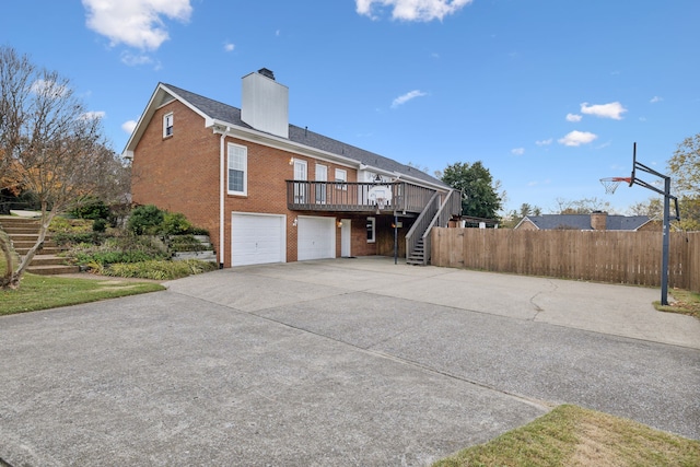 rear view of property with a garage and a wooden deck