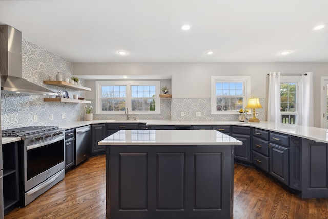 kitchen with stainless steel appliances, backsplash, dark hardwood / wood-style floors, and wall chimney range hood