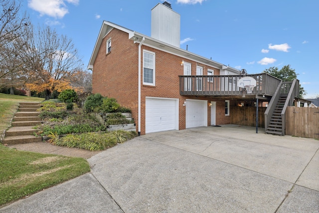 view of side of property featuring a wooden deck and a garage